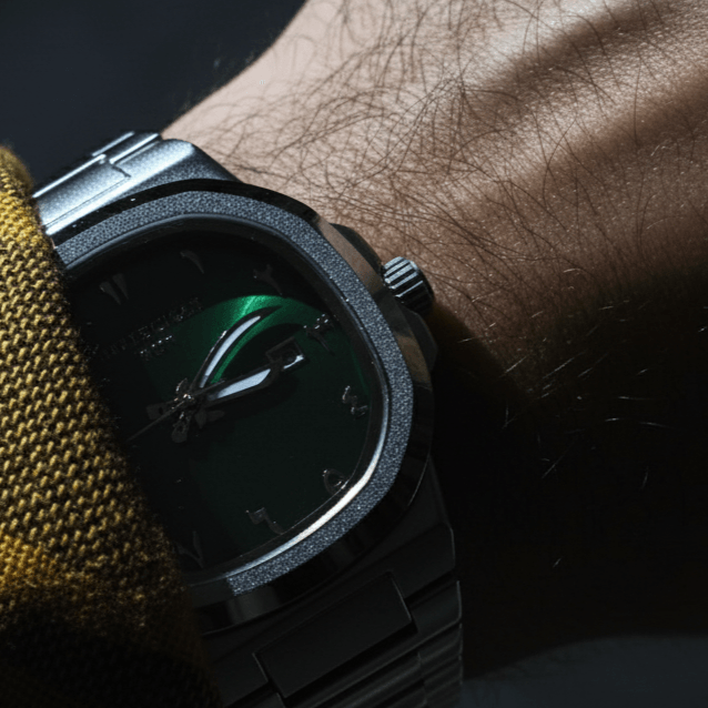 Casablancan Al-Riyadh Heritage 43mm Arabic Dial Watch with green sunray face, Khanjar hands, and stainless steel bracelet on wrist. Features Eastern Arabic numerals.
