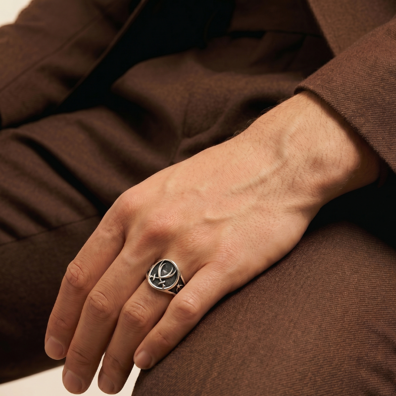 Hand wearing a casablancan arabic silver ring with a design, against a brown background
